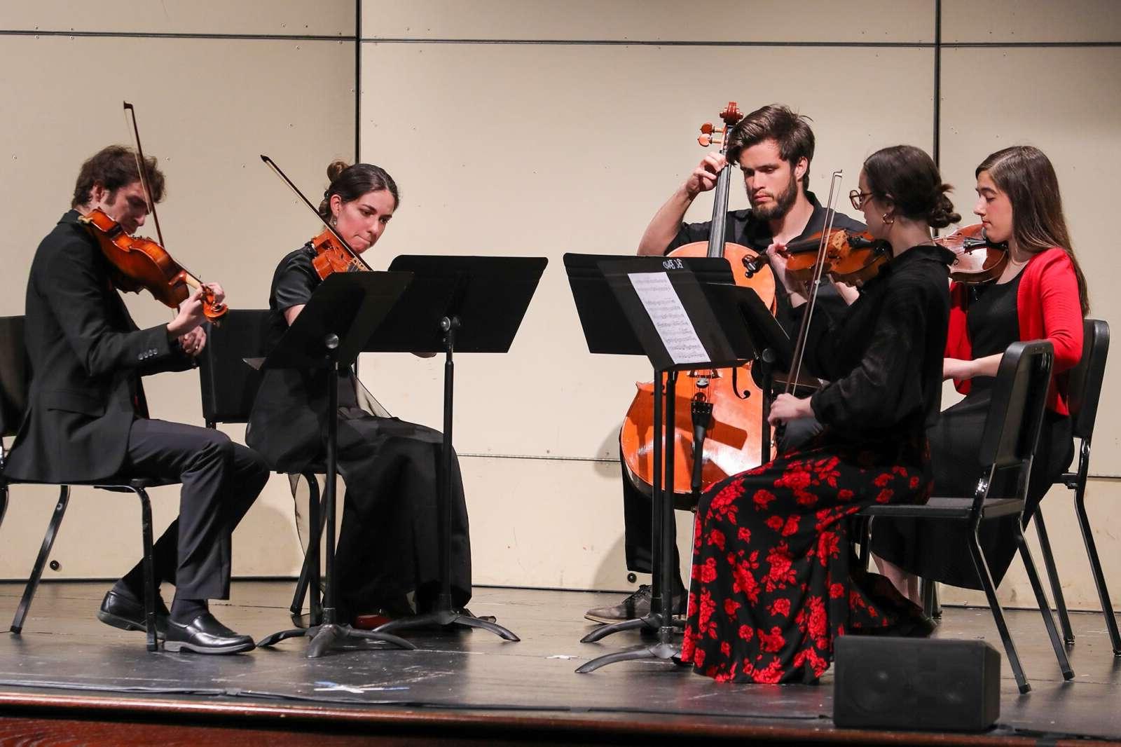 Students performing in a string quintet